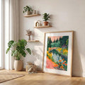 Matted colorful landscape poster displayed in a living room corner