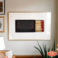 Minimal matchbox quote poster leaning on warm neutral shelf