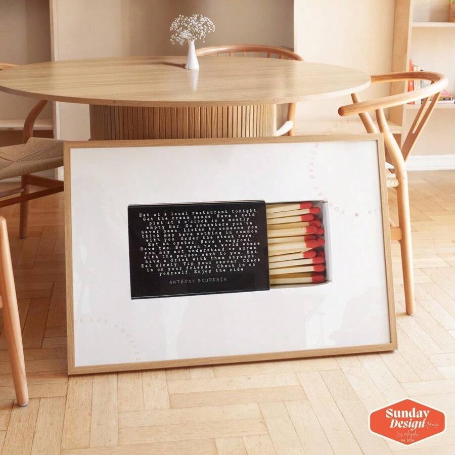 Anthony Bourdain quote poster with matchbox and red matches in wood frame