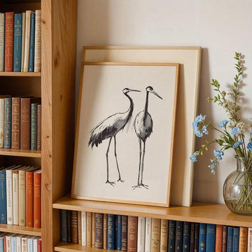 Japanese crane sketch poster in wood frame on bookshelf with books and blue flowers