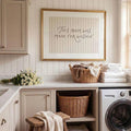 Farmhouse laundry wall art staged above washer towels and wicker baskets in neutral utility room