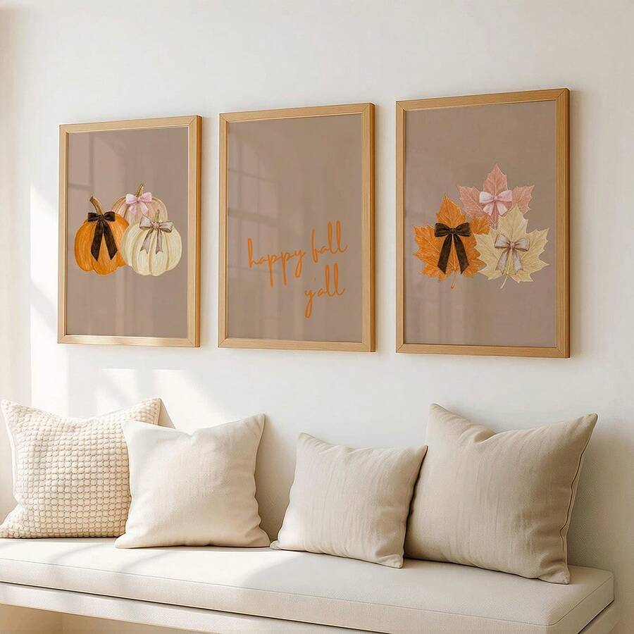 Autumn canvas poster trio in warm frames above a cream bench with sunlight reflections