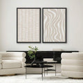 Geometric abstract canvas pair above cream chairs