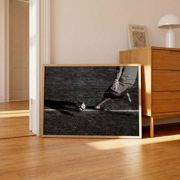 Football kick canvas poster beside wood dresser