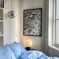 Leopard eye canvas poster above blue bedding