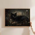 Minimal wall display of dark pastoral black cat wildflower poster held by hand against pale wall