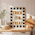 Trick Or Treat plaid Halloween poster on kitchen counter with wood frame tile backsplash bowls vase and cutting board