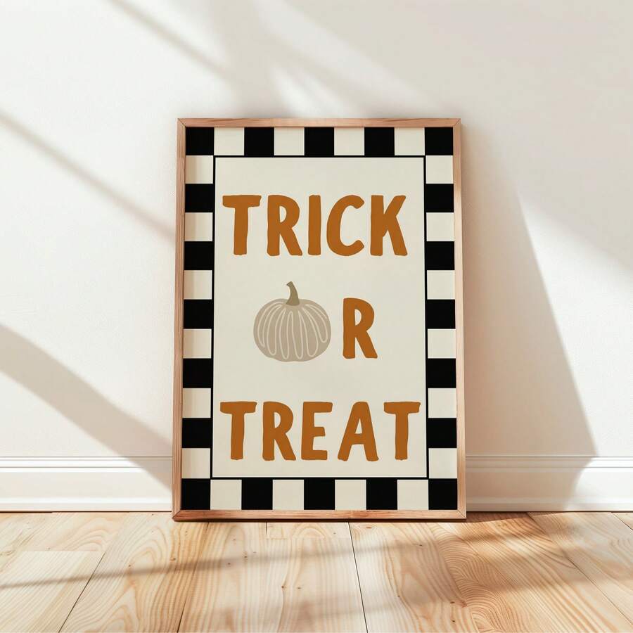 Trick Or Treat plaid Halloween poster in light wood frame leaning against cream wall with sun shadows