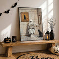 Halloween wall art of ghost reading newspaper on toilet black cat nearby bat garland and pumpkins around bench