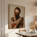 Gold framed earth tone portrait above marble dining table with cane chairs