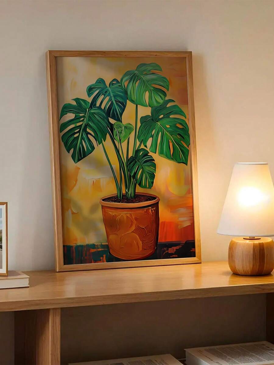 Framed tropical plant artwork displayed on a wood console with table lamp
