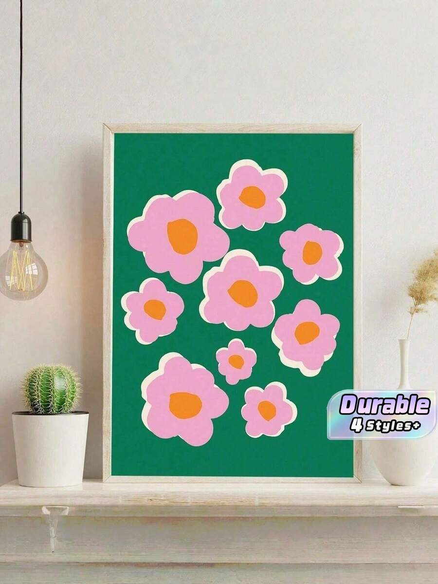 Pink flower canvas poster in light wood frame beside cactus and pendant bulb