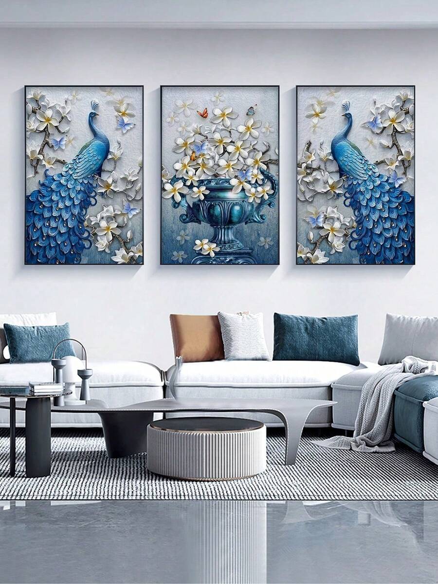 Three framed 3D effect blue peacock and floral vase prints above modern white sofa in living room