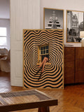 Large abstract female-legs window print leaning in eclectic living room with wood furniture