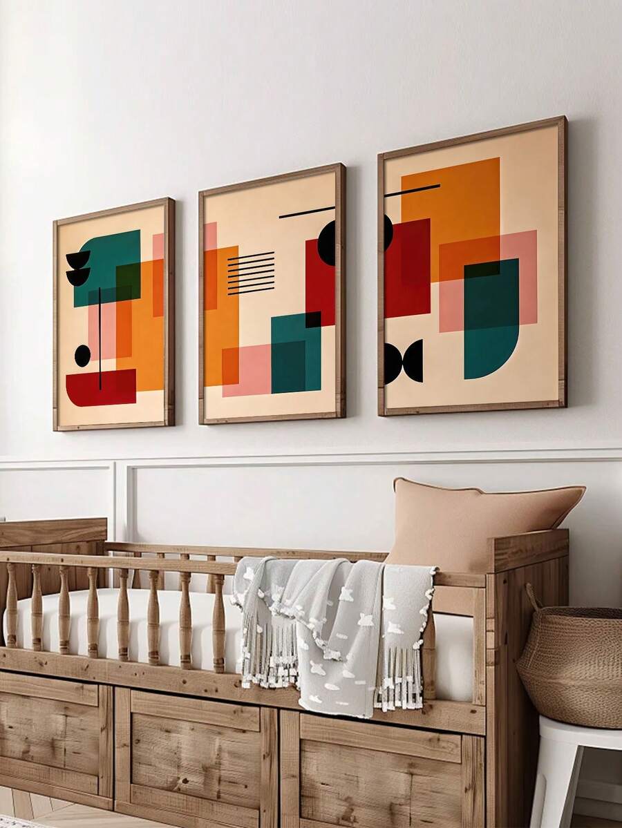Three framed mid century geometric posters above wooden crib in nursery