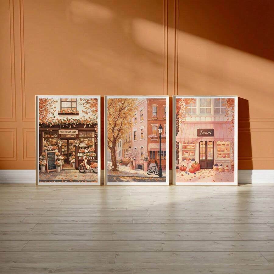 Three autumn storefront canvases leaning on terracotta wall