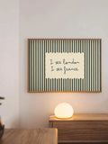 Blue-green striped I see London I see France poster above cabinet and lamp
