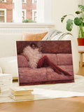 Unframed reclining woman and pink sofa canvas resting on white bench near window