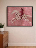 Star-covered white horse and red-clad rider print above wood dresser with plants