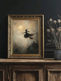 Lone broomstick witch and haunted house in ornate gold frame