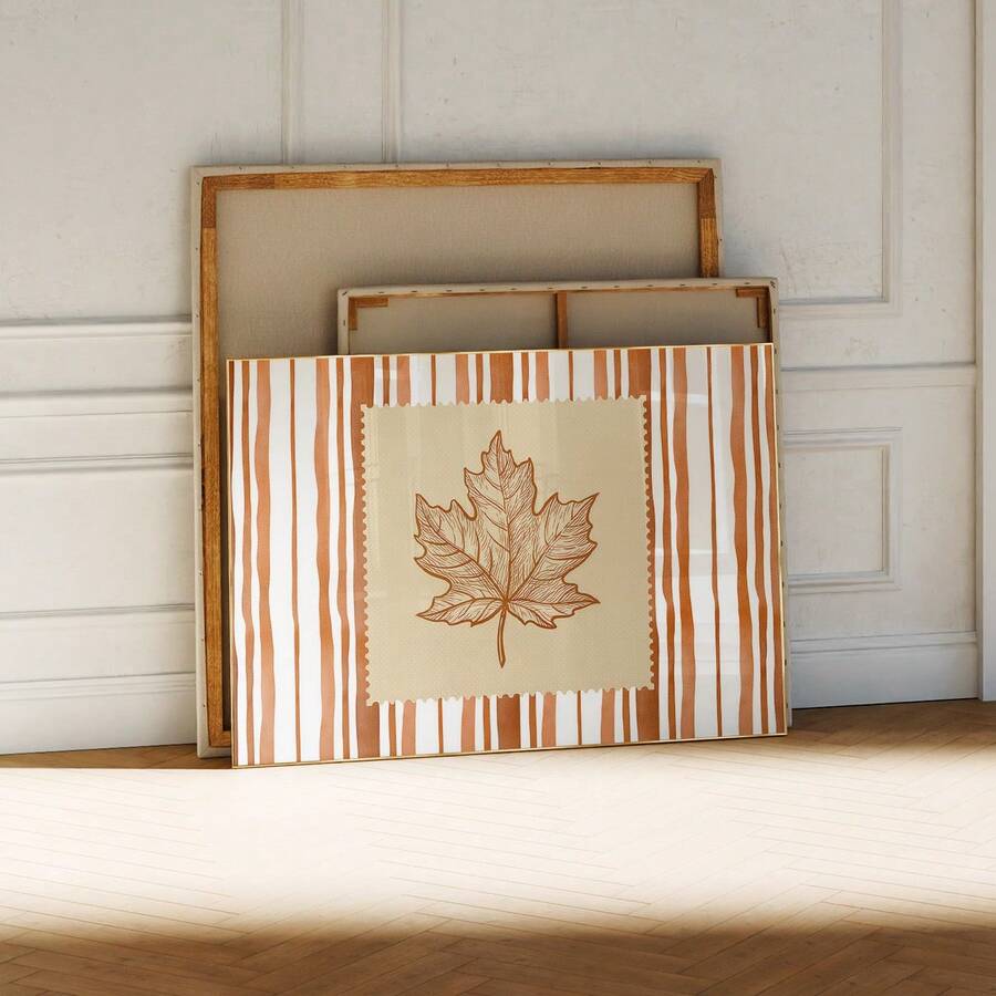 Unframed maple leaf canvas art leaning against wood supports