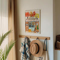 White framed autumn coffee shop artwork displayed above entryway hooks