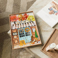 Framed fall café print styled on a table with candles and neutral decor