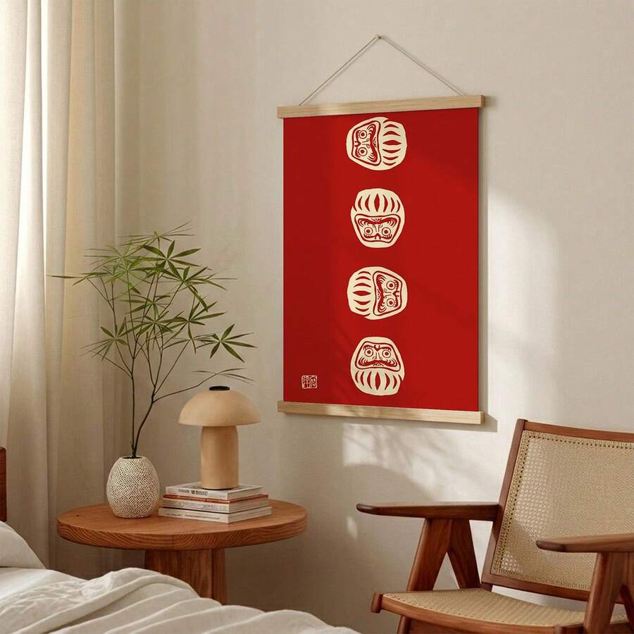 Daruma doll poster with wooden hanger displayed above a console and chair
