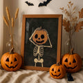 Skeleton holding a jack-o-lantern head artwork in a wooden display frame surrounded by carved pumpkins and dried autumn stems