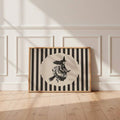 Vintage witch broom poster in a light wood frame mockup against a paneled wall