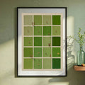 Black framed green grid print on a sage wall beside a glass vase