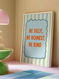 Be Silly Be Honest Be Kind kids quote wall art in a light frame styled on a bedside shelf