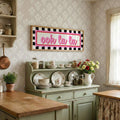 Ooh la la retro wall art adding pink accent above cottage kitchen hutch