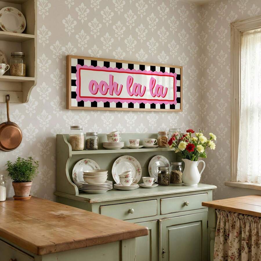 Ooh la la retro wall art adding pink accent above cottage kitchen hutch