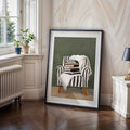 Black-framed reading-chair print below window with plants, radiator and side lamp
