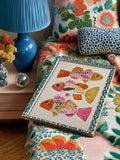 Three illustrated fish in a blue patterned frame on a floral armchair