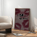 Love typography poster in a wood frame beside a lounge chair