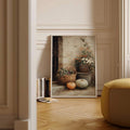 Framed rustic pumpkin still life leaning beside books in a paneled room