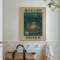 Onsen frog artwork hanging above a woven basket and wall hooks in a bright entryway
