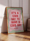 Sunlit angled close-up of pink and green good day typography artwork