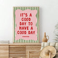 Pink and green motivational print displayed above a wood sideboard with woven decor