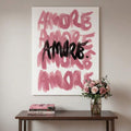 Large pink and dark Amore lettering canvas displayed on a console