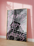 Close angled view of framed Eiffel Tower print with pink Paris script against a pink wall
