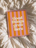 Pink framed Good things grow here striped print resting on cream bedding