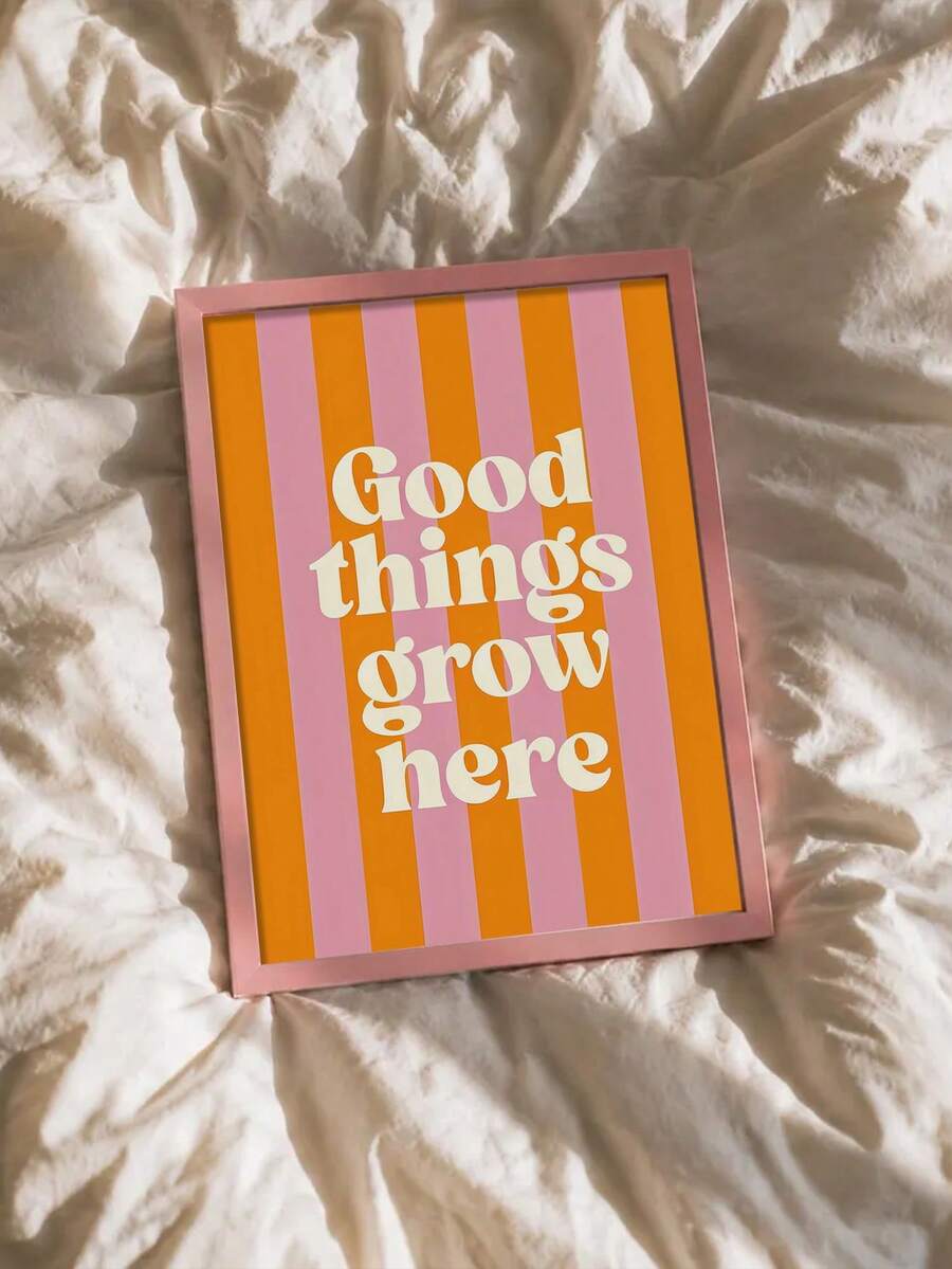 Pink framed Good things grow here striped print resting on cream bedding