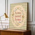 Framed home sweet home floral sampler leaning beside a brass lamp