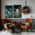 Black-framed ghost botanical prints above rust armchairs and an autumn wreath