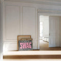 Pink SWAG animal print wall art layered with canvases on parquet flooring