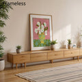 Floral vase print above long wood console with potted plants