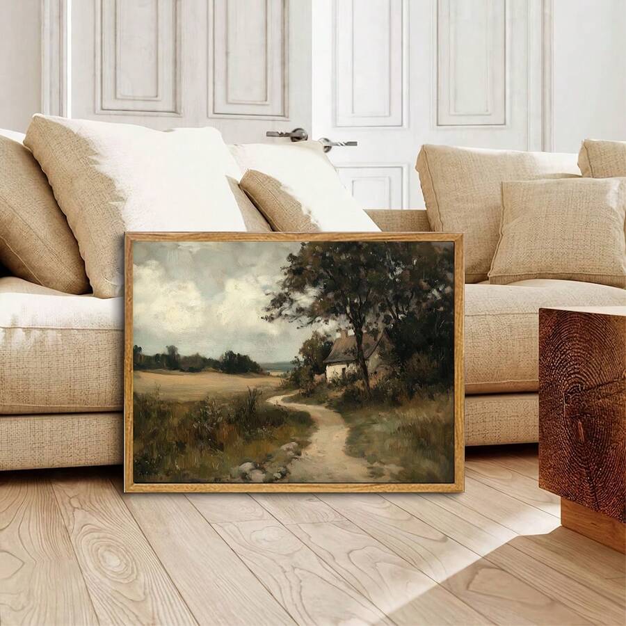 Pastoral cottage canvas displayed near a neutral sofa